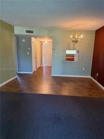 an empty room with wooden floor and bathroom view