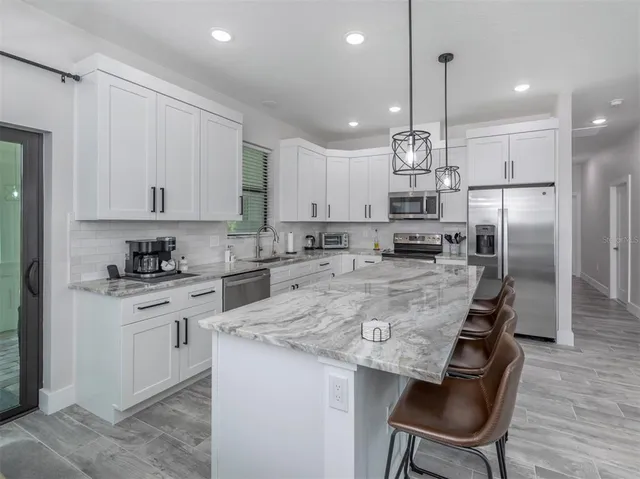 a view of a dining room and livingroom view with furniture wooden floor and a chandelier