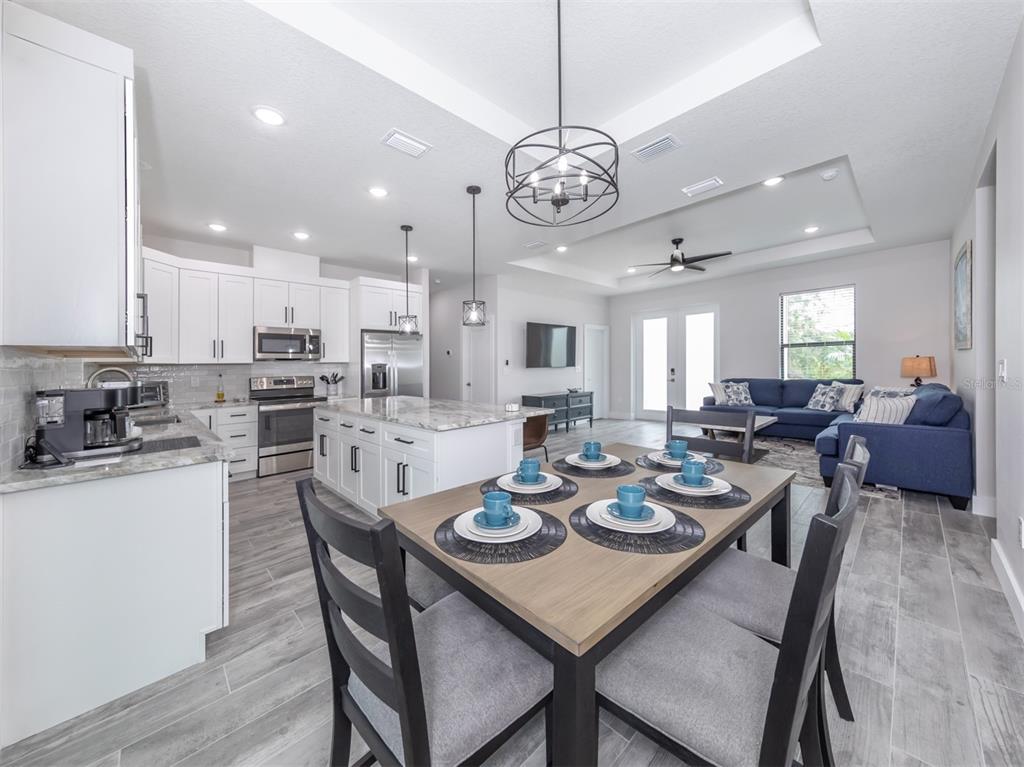17566 De Miranda Avenue North Port, FL 34287 - Photo 13 of 94 a view of a dining room and livingroom view with furniture wooden floor and a chandelier