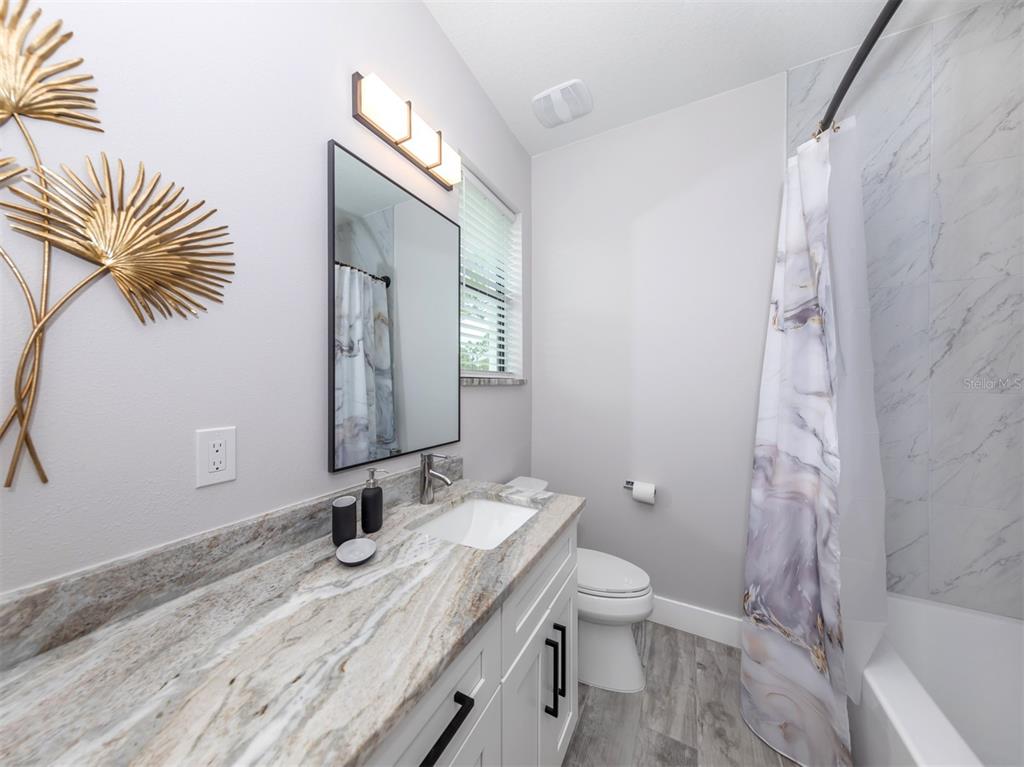 17566 De Miranda Avenue North Port, FL 34287 - Photo 18 of 94 a bathroom with a granite countertop sink toilet and shower