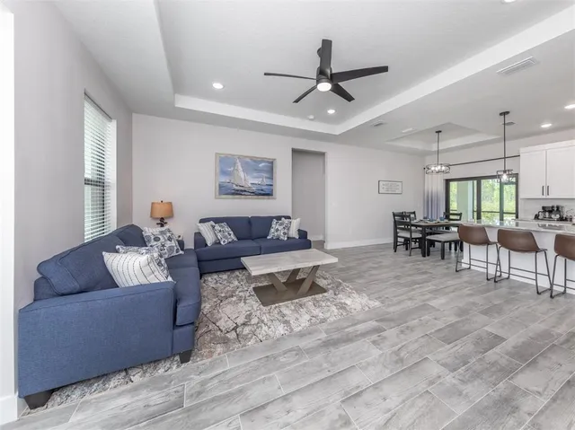 a living room with furniture and a view of kitchen
