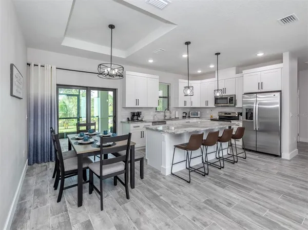 a large kitchen with stainless steel appliances kitchen island granite countertop a large counter top a stove a sink and a refrigerator