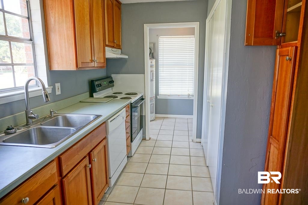 4366 Fathbrook Lane Mobile, AL 36693 - Photo 8 of 14 Kitchen with under cabinet range hood, a sink, white appliances, light tile patterned flooring, and plenty of natural light