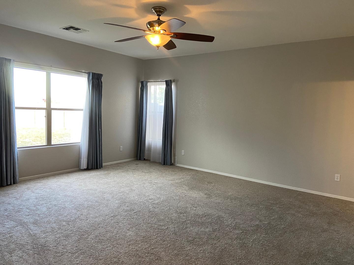 1330 East Pedro Road Phoenix, AZ 85042 - Photo 14 of 50 an empty room with windows and chandelier fan