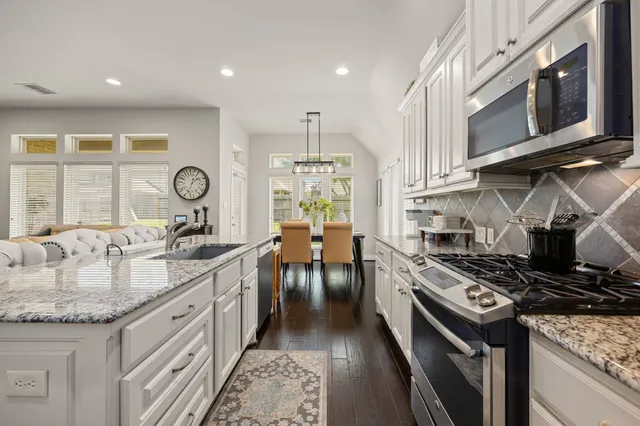 a kitchen with stainless steel appliances granite countertop a stove and a sink