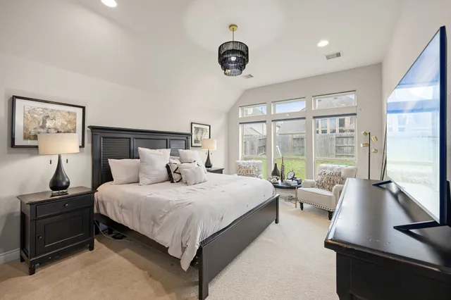 a bedroom with a bed and a large window