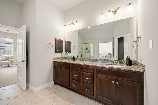 a bathroom with a granite countertop sink double and mirror