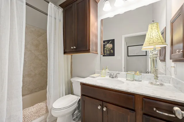 a bathroom with a granite countertop toilet sink and mirror