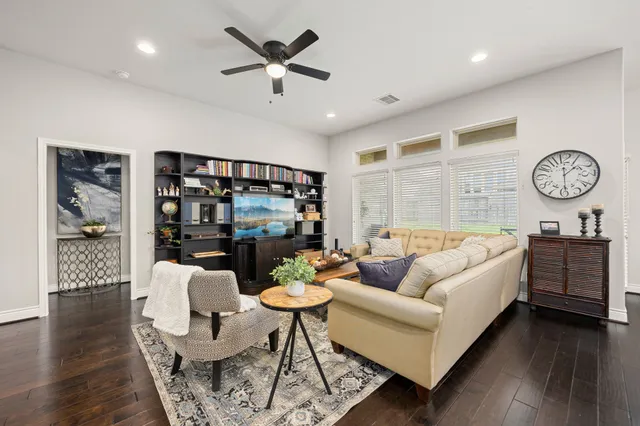 a living room with furniture a chandelier and a wooden floor
