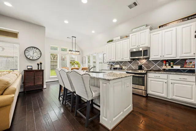 a kitchen with a sink cabinets and wooden floor