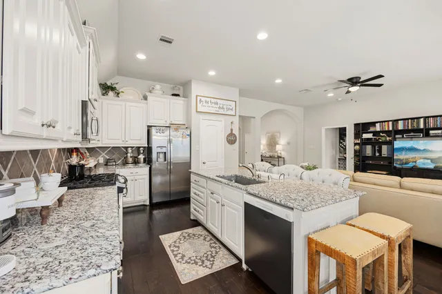 a kitchen with stainless steel appliances granite countertop a sink stove and refrigerator