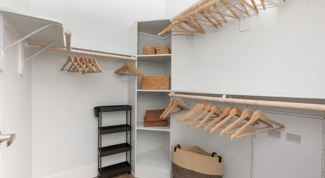 a view of walk in closet with clothes and shoes