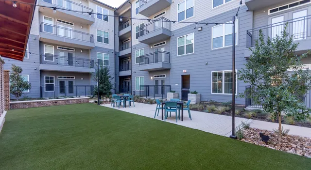 a view of a building with a garden and sitting area