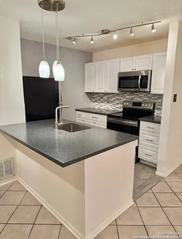 a kitchen with stainless steel appliances granite countertop a stove microwave and refrigerator