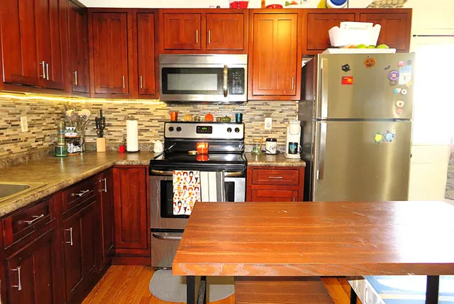 a kitchen with stainless steel appliances granite countertop a refrigerator stove top oven with a sink and dishwasher