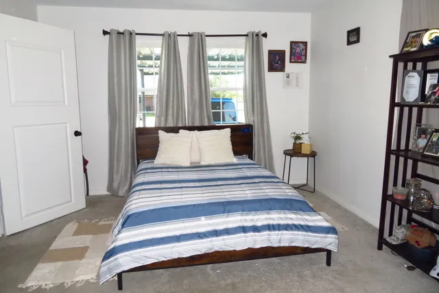 a spacious bedroom with a bed and a book shelf
