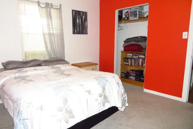 a bed sitting in a bedroom next to a window