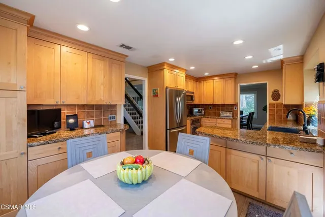 a kitchen with granite countertop a refrigerator stove and microwave