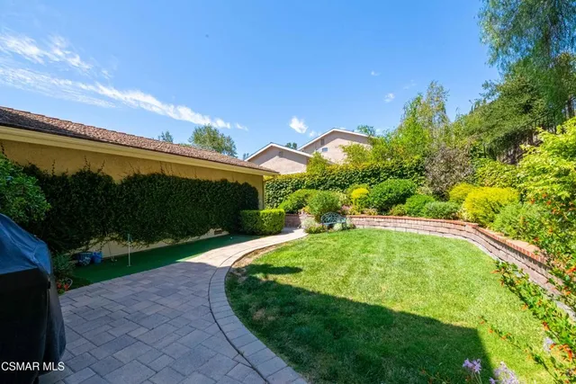 a view of a backyard with plants and a patio