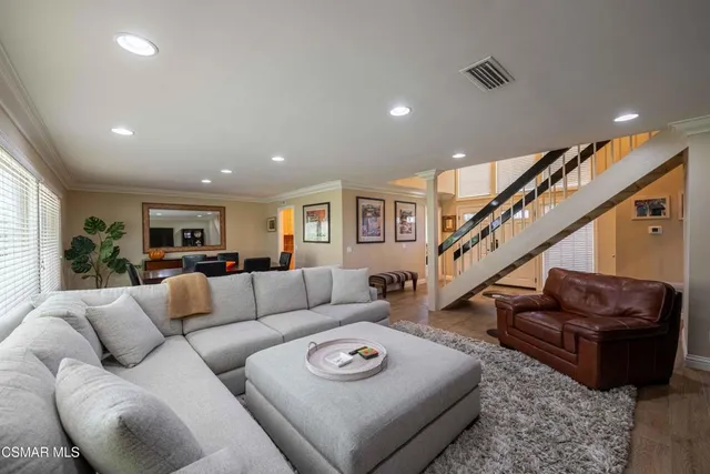 a living room with furniture a flat screen tv and a table