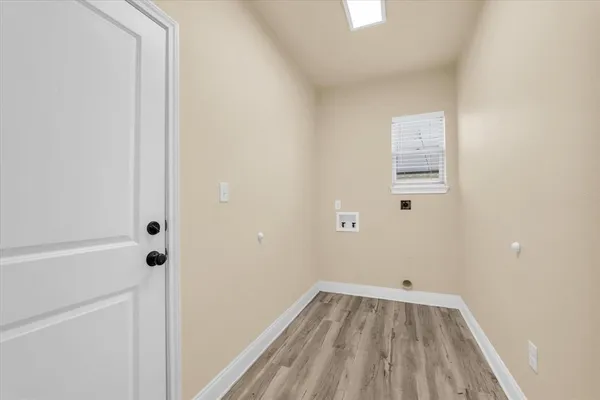 a view of a small space with wooden floor and a window