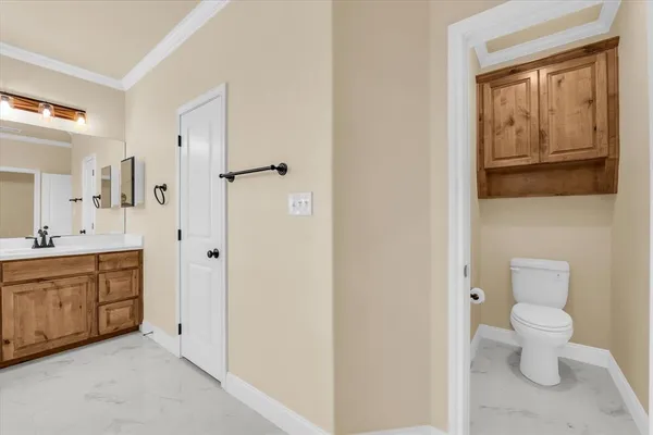 a bathroom with a granite countertop toilet a sink and a mirror