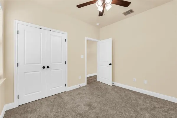 an empty room with chandelier fan