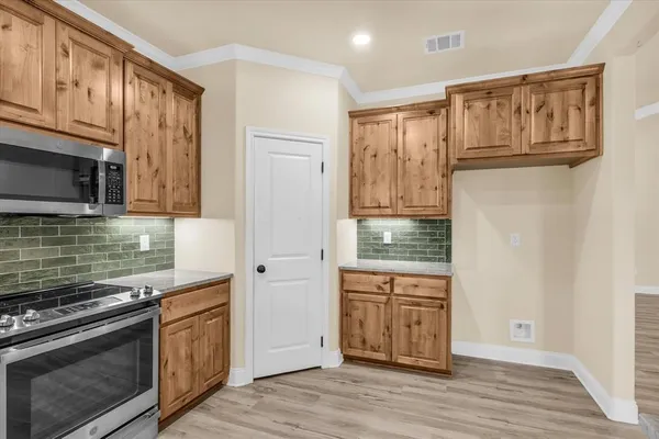 a kitchen with stainless steel appliances granite countertop a refrigerator and a stove top oven