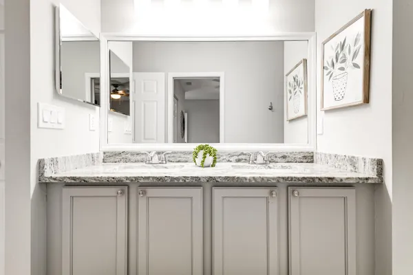 a bathroom with a granite countertop sink and a mirror