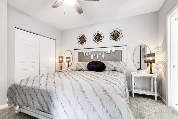 a bedroom with a bed a couch and a chandelier
