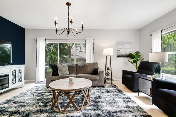 a living room with furniture a chandelier and a dining table