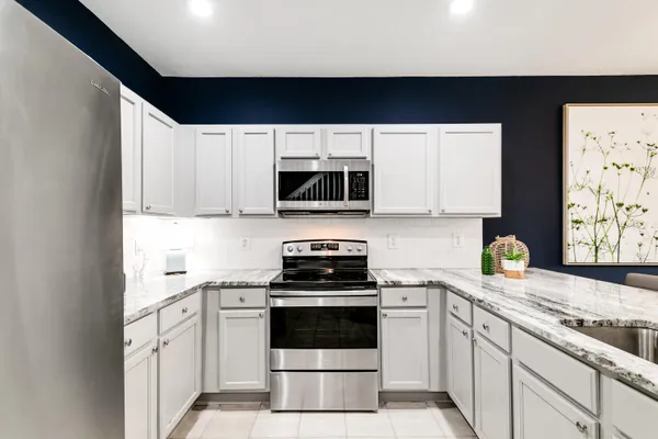 a kitchen with stainless steel appliances a stove a microwave sink and cabinets