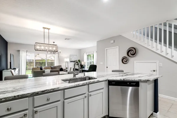 a kitchen with granite countertop a sink a stove and cabinets
