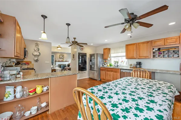 a kitchen with stainless steel appliances granite countertop a sink dishwasher and a stove with wooden floor