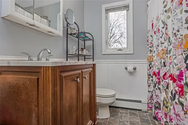 a bathroom with a granite countertop toilet sink and mirror