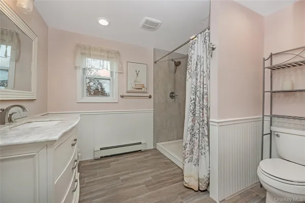 a bathroom with a granite countertop sink toilet and shower