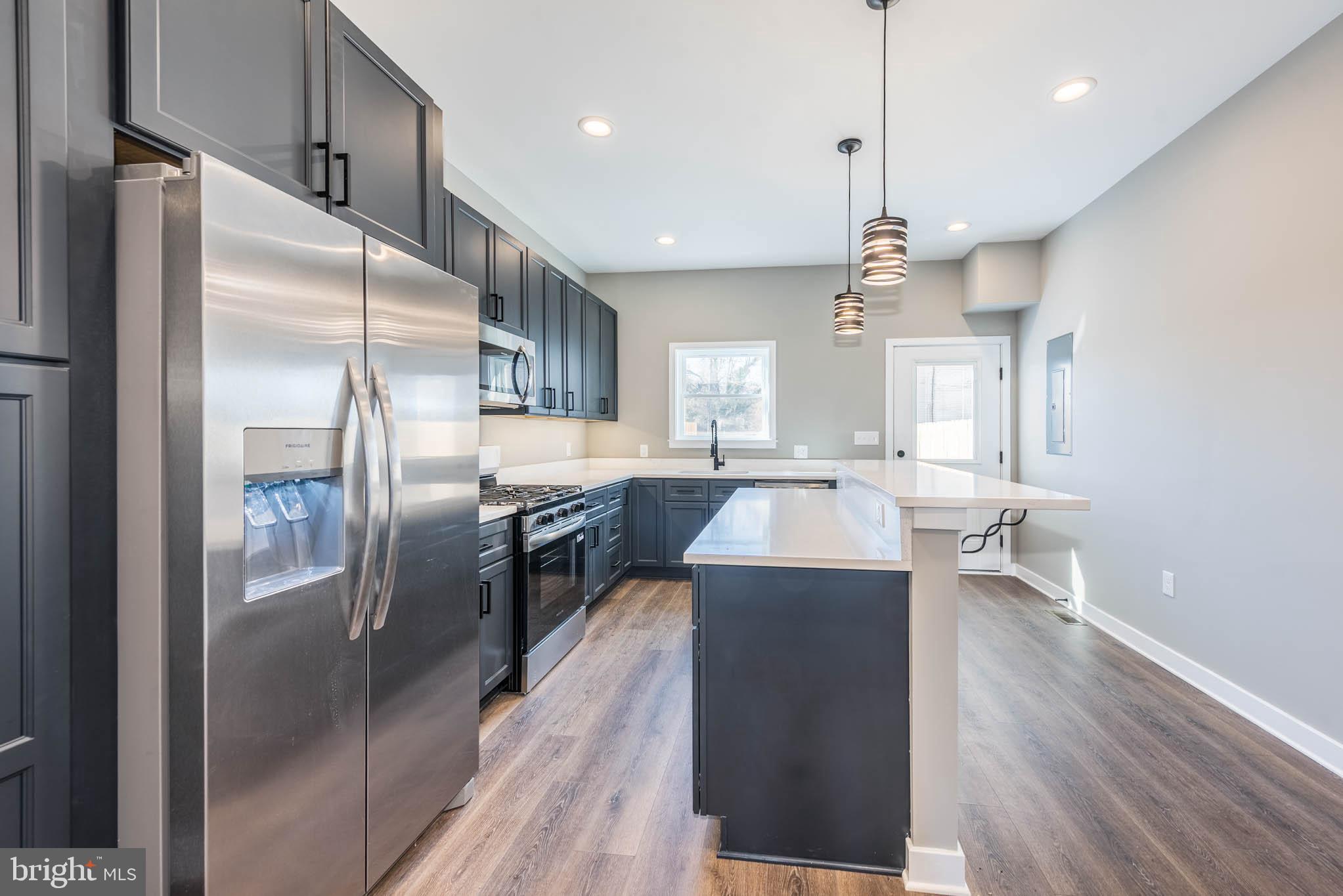 1330 Division Street Baltimore, MD 21217 - Photo 12 of 39 a kitchen with kitchen island a counter top space a sink appliances and cabinets