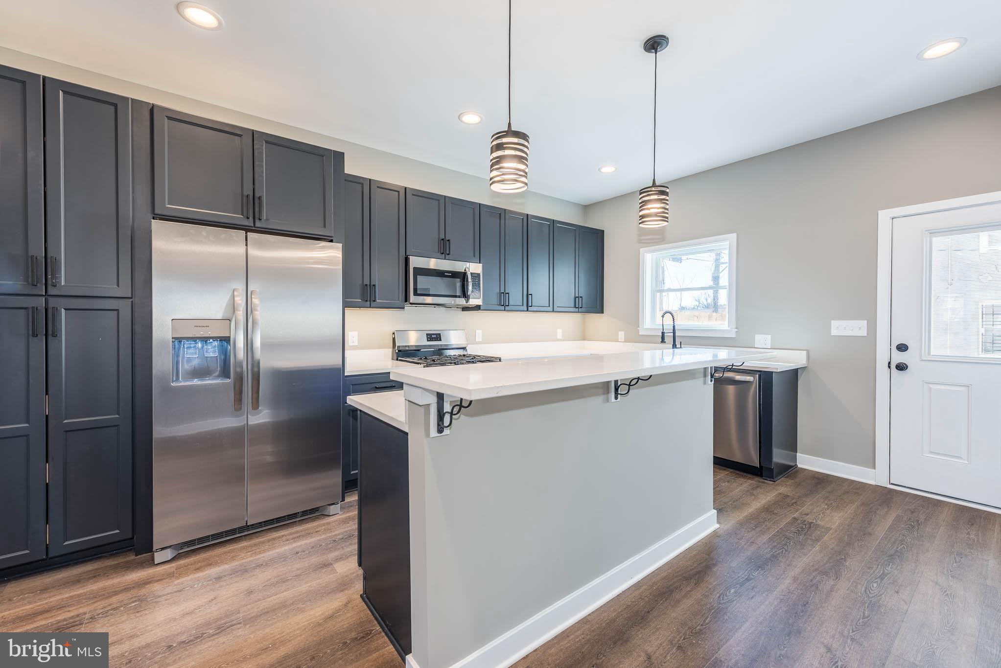 1330 Division Street Baltimore, MD 21217 - Photo 13 of 39 a kitchen with kitchen island granite countertop a center island a refrigerator and a sink
