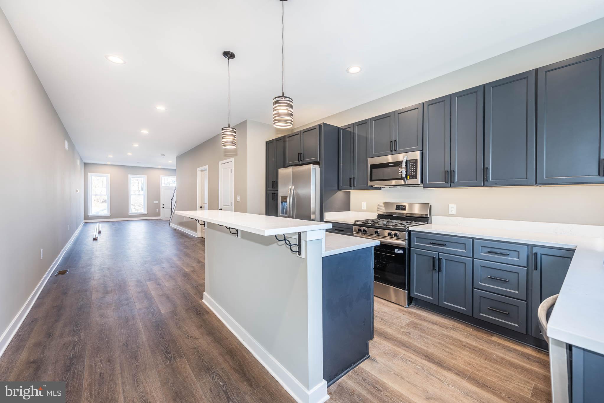 1330 Division Street Baltimore, MD 21217 - Photo 14 of 39 a kitchen with stainless steel appliances granite countertop wooden cabinets a refrigerator a stove a sink and a wooden floors