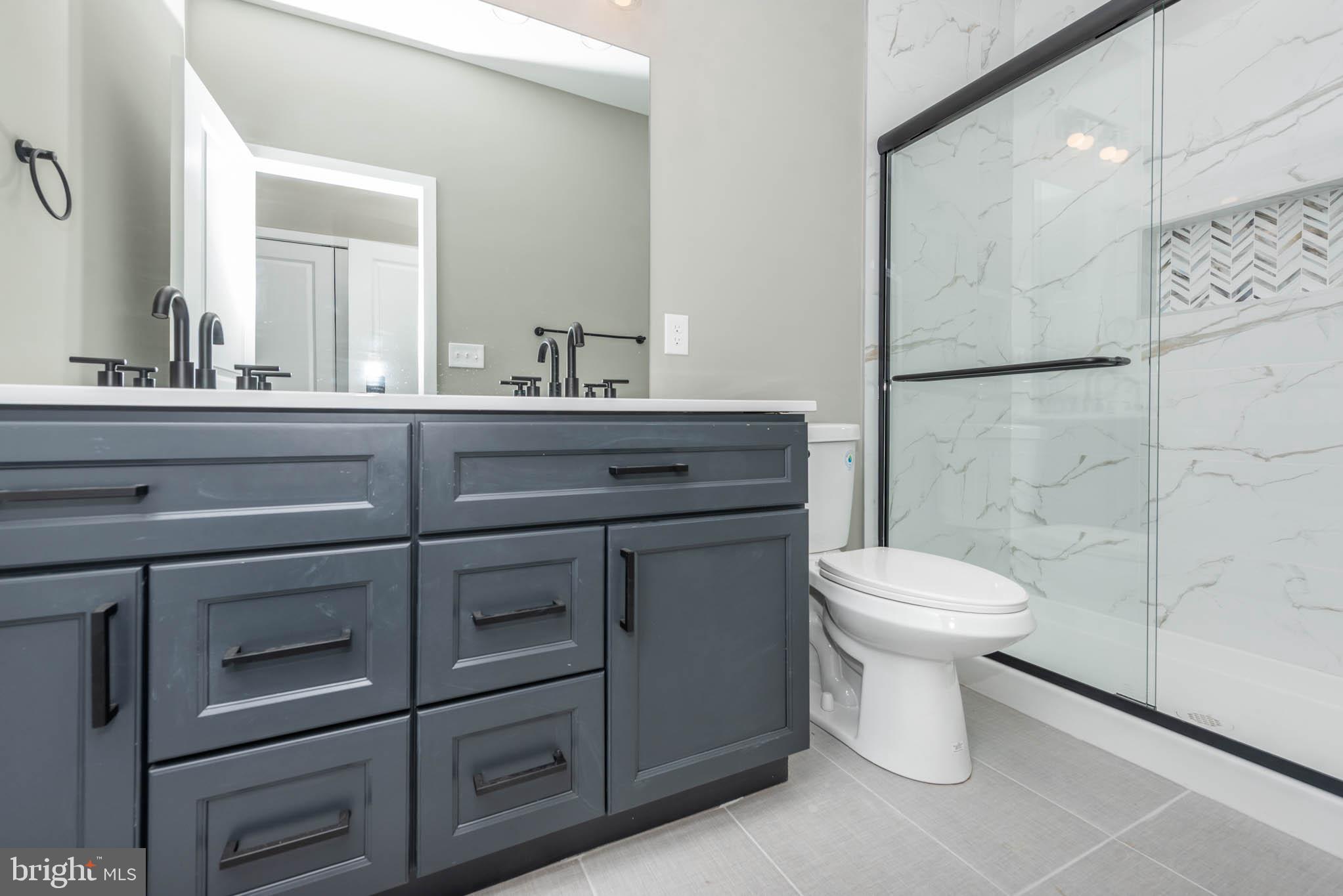 1330 Division Street Baltimore, MD 21217 - Photo 21 of 39 a bathroom with a toilet sink and mirror
