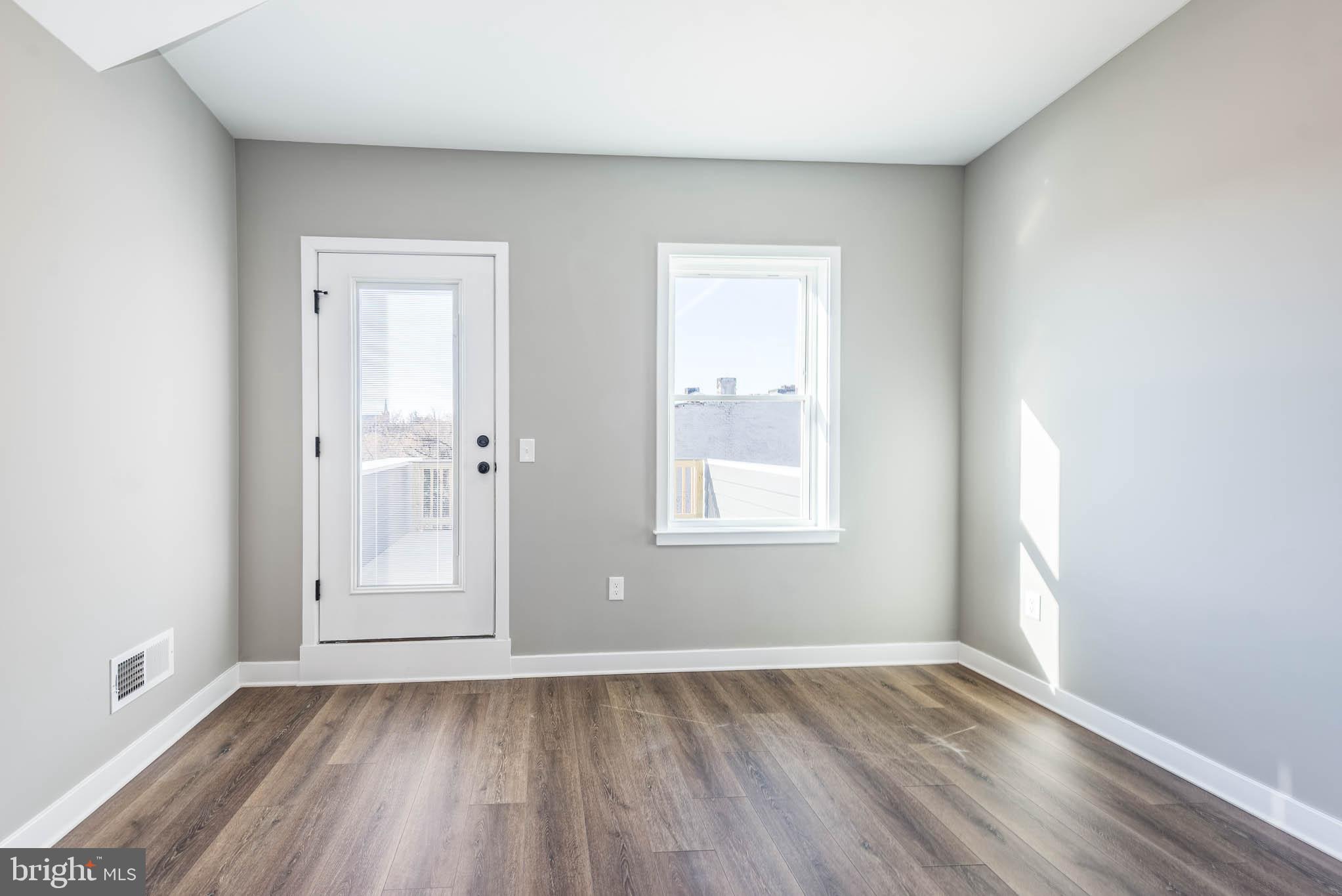 1330 Division Street Baltimore, MD 21217 - Photo 23 of 39 an empty room with wooden floor and windows