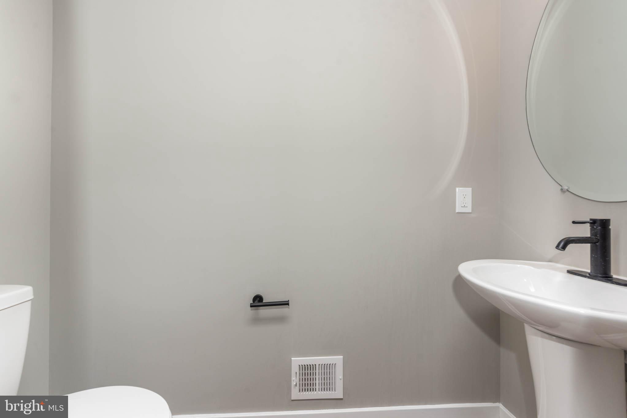 1330 Division Street Baltimore, MD 21217 - Photo 7 of 39 a bathroom with a sink mirror and toilet