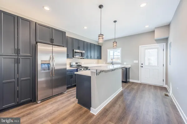 a kitchen with kitchen island a counter space a sink appliances and cabinets