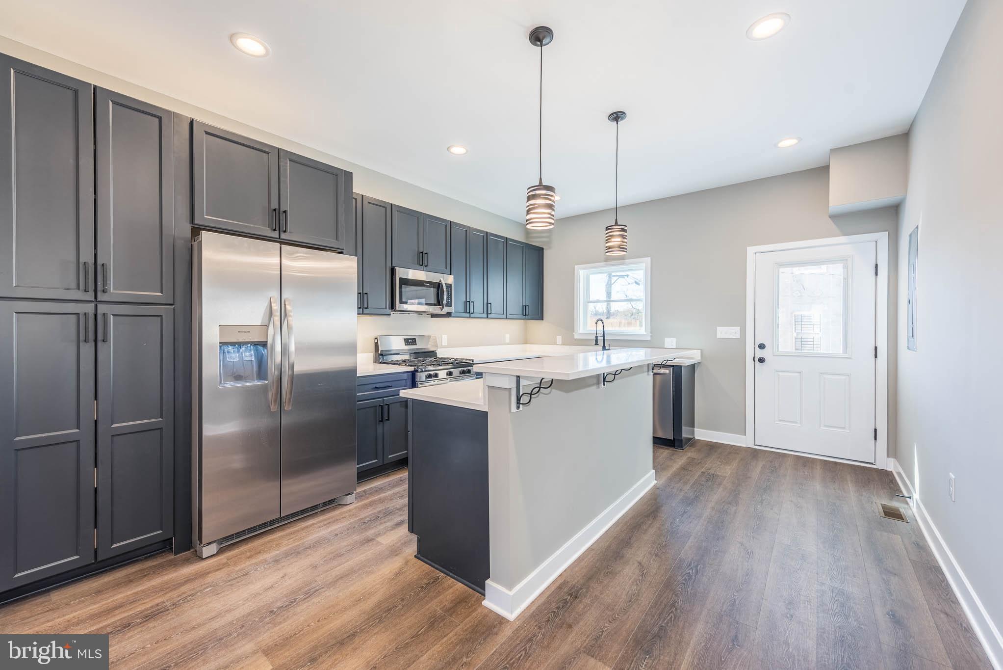 1330 Division Street Baltimore, MD 21217 - Photo 9 of 39 a kitchen with kitchen island a counter space a sink appliances and cabinets