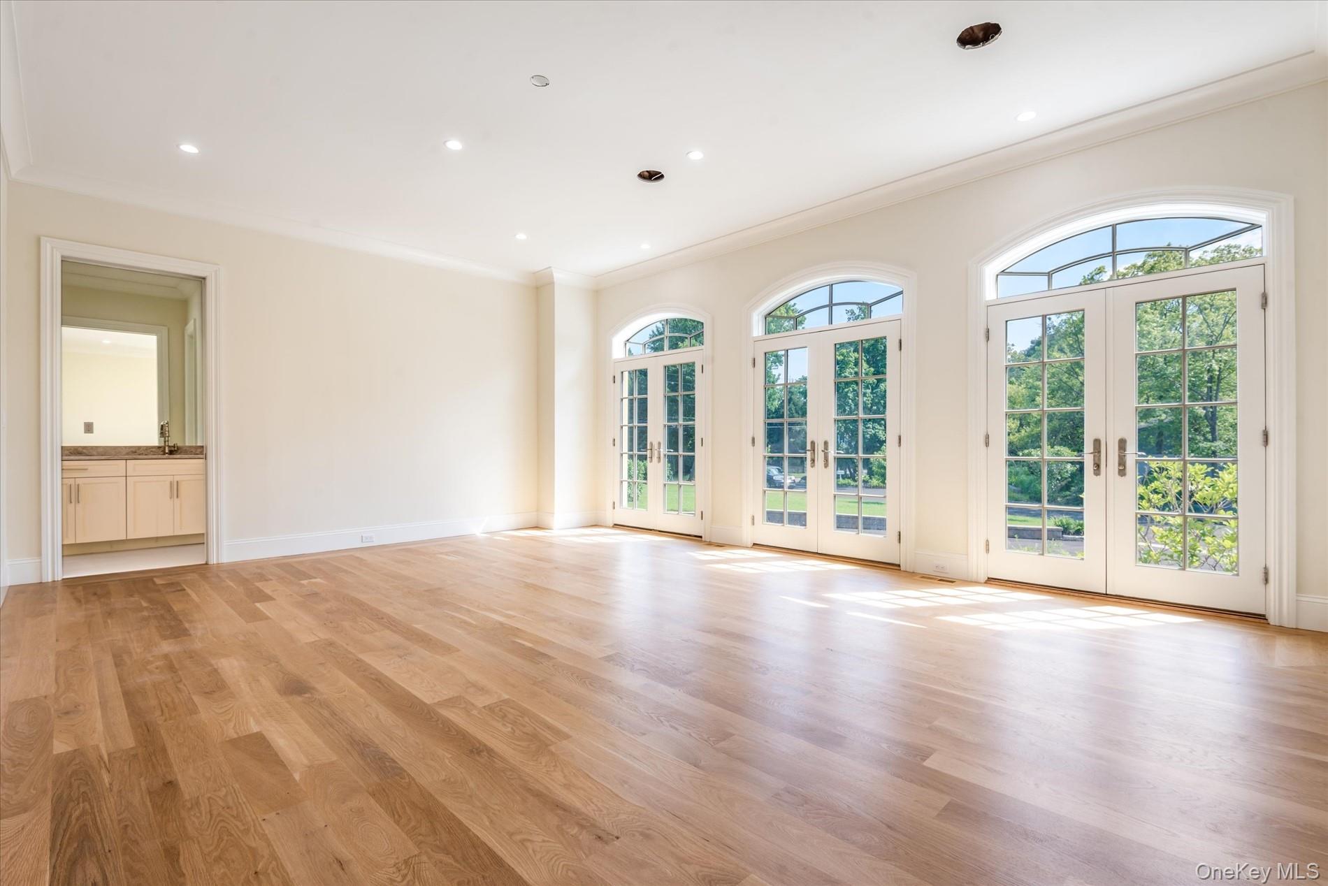 566 A East Shore Road Queens, NY 11024 - Photo 16 of 42 Spare room featuring french doors, plenty of natural light, crown molding, light wood-type flooring, and recessed lighting