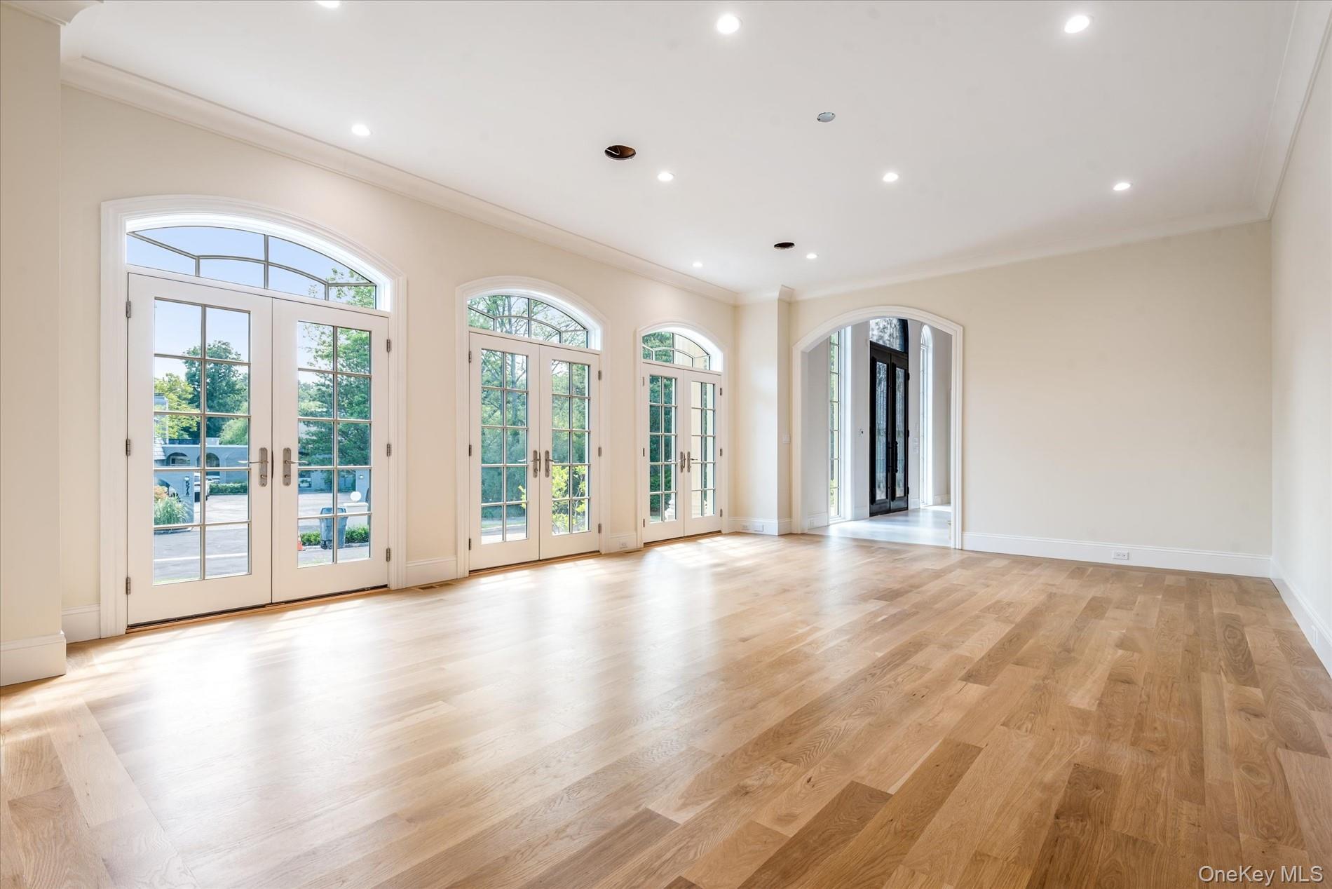 566 A East Shore Road Queens, NY 11024 - Photo 17 of 42 Unfurnished room featuring french doors, crown molding, recessed lighting, light wood finished floors, and arched walkways