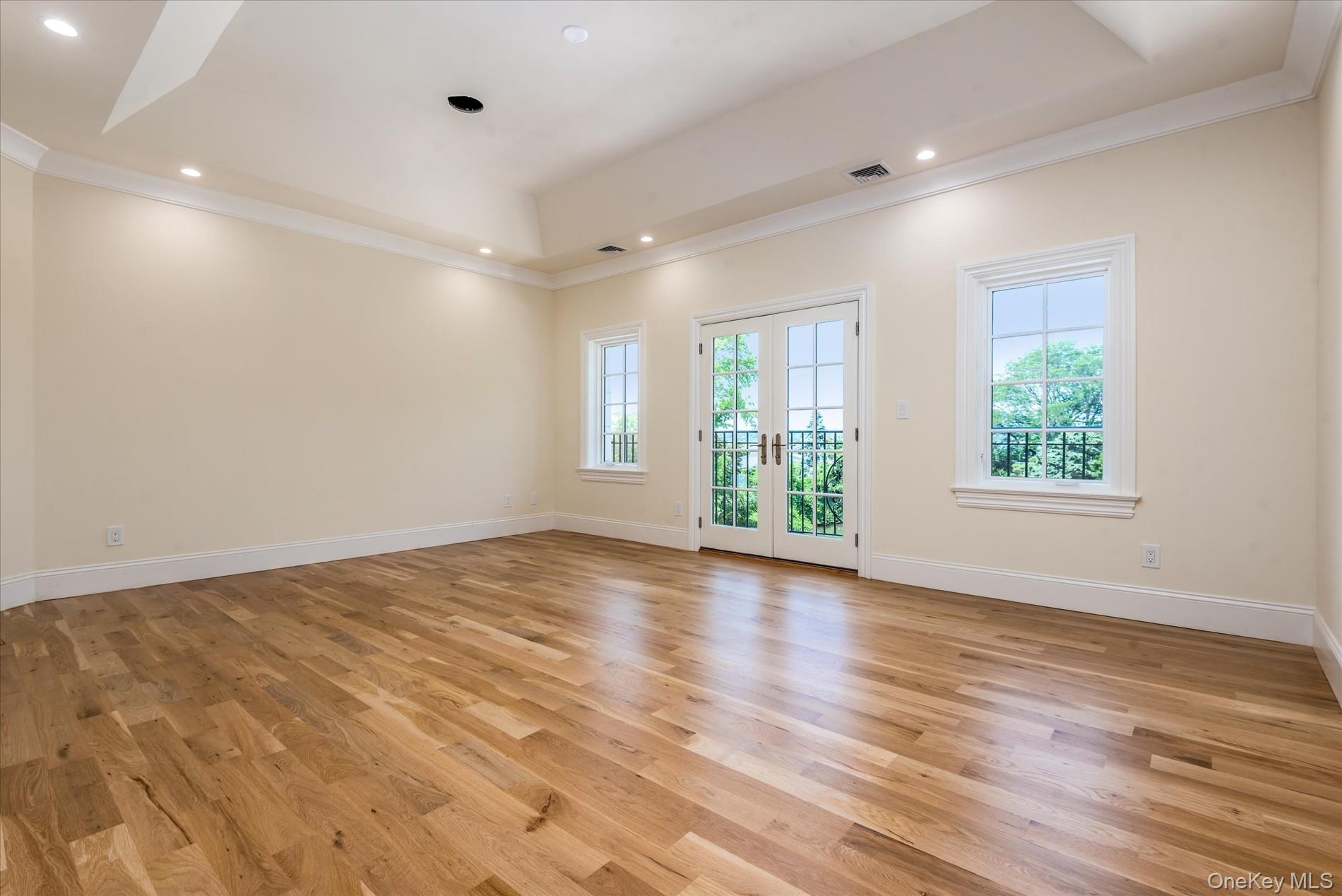 566 A East Shore Road Queens, NY 11024 - Photo 26 of 42 Unfurnished room featuring a raised ceiling, french doors, ornamental molding, light wood-type flooring, and recessed lighting