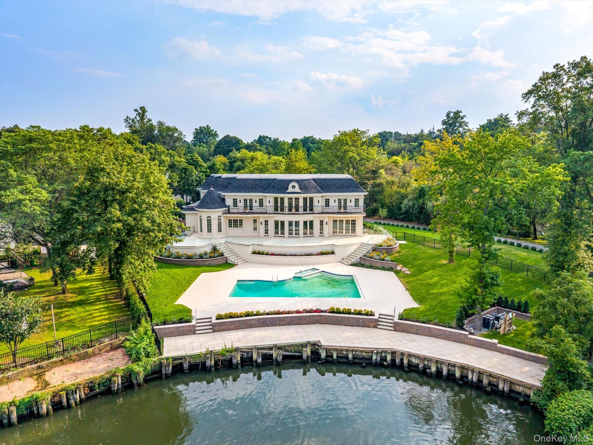 566 A East Shore Road Queens, NY 11024 - Photo 33 of 42 Rear view of house featuring stairway, a patio area, a fenced backyard, and a water view