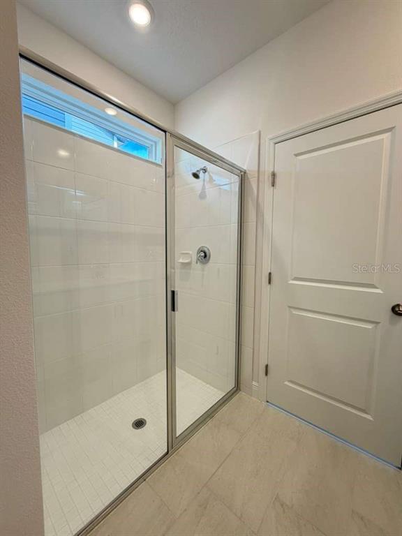 2265 Hen Road Minneola, FL 34715 - Photo 19 of 36 a bathroom with a glass shower door