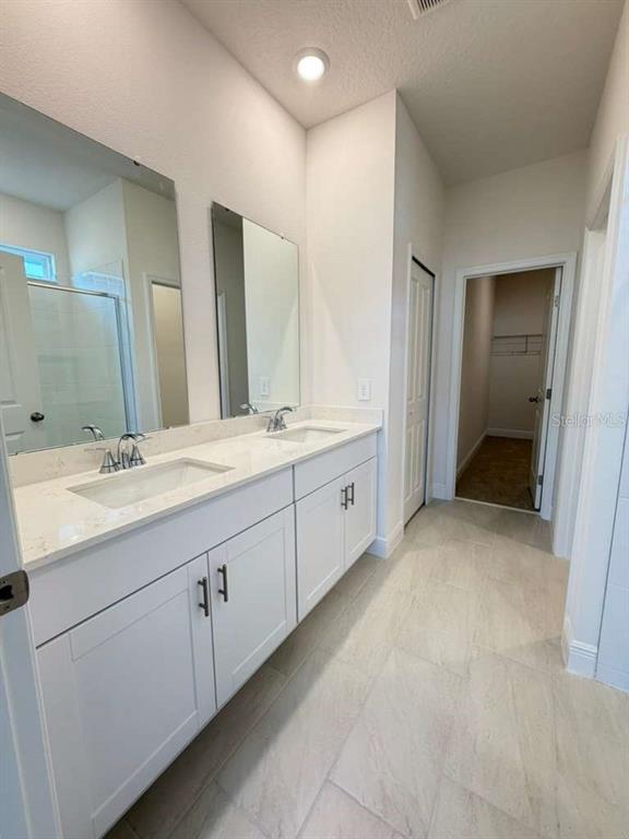 2265 Hen Road Minneola, FL 34715 - Photo 20 of 36 a bathroom with a double vanity sink and mirror